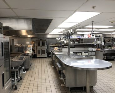 commercial kitchen: griddle, convection ovens, and prep area