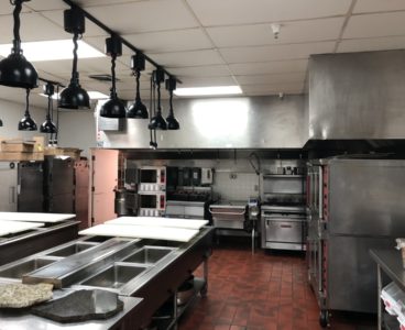 commercial kitchen: convection ovens, stove, and prep area