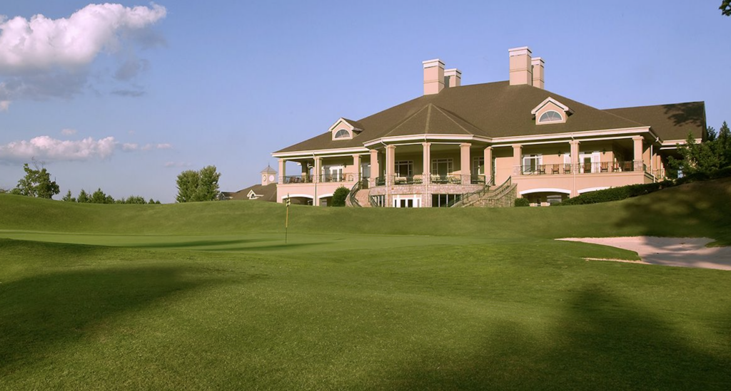 clubhouse behind a golf green